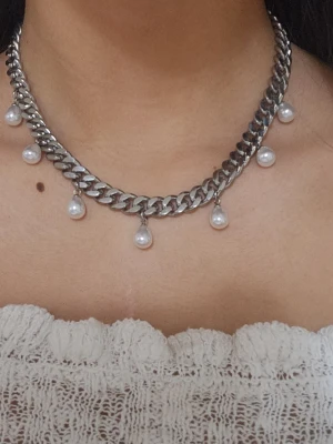 Silvrigt 9mm bred halsband med droppformade pärlor. - Elegant halsband i rostfritt stål från Diavansa Smycken – finns även i en guldpläterad variant. Matchande örhängen finns i en separat annons. Smycket är 9 mm brett och har en justerbar längd mellan 38–43 cm, vilket gör att det passar perfekt oavsett stil och tillfälle. De nickeltestade och handgjorda. 
