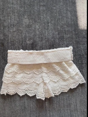 Vita virkade shorts med spetsdetaljer - Spetsshorts, köptes i en marknad utomlands, stretchiga o passar flera storlekar💕