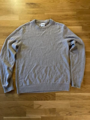 Beige stickad tröja från Dobber - Klassisk beige stickad tröja från Dobber med rund halsringning och ribbade muddar vid ärmslut och nederkant. Enkel och stilren design som passar till det mesta. Perfekt för lager på lager och en avslappnad look.