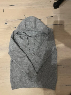 Grå Kashmir hoodie från Gardegrisch  - Väldigt bra skick Kashmir hoodie inga hål, defekter eller missfärgningar. Är själv 173 cm och den är precis. Skulle passa någon som är runt 165-170 hör gärna av er vid intresse eller om man vill ha fler bilder 