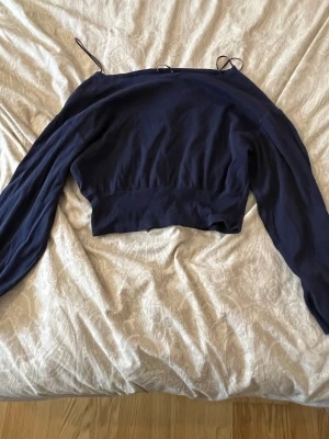 Mörkblå croppad topp Gina Tricot - Säljer en mörkblå croppad topp från Gina Tricot med långa ärmar. Toppen har en tight passform och är tillverkad i ett mjukt, stretchigt material. Perfekt att styla med jeans eller kjol.