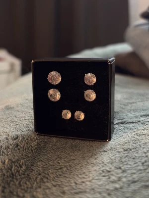 Set med tre par glittriga örhängen - Säljer ett set med tre par silvriga stenörhängen i olika storlekar. Helt oanvända💕