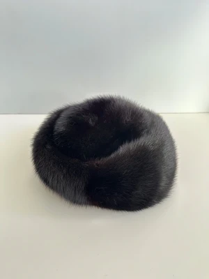 Svart pälsmössa i klassisk stil - Elegant pälsmössa med rund form. Mössan har en tidlös design och är perfekt för kalla dagar. Materialet är äkta päls vilket ger en lyxig känsla.