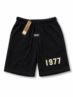 Svarta Essentials shorts med tryck - Svarta shorts från Essentials med resårmidja och snörning. Trycket '1977' i beige framtill ger en cool vibe. Tillverkade i mjuk bomull för maximal komfort. Perfekta för avslappnade dagar och streetwear-stil.