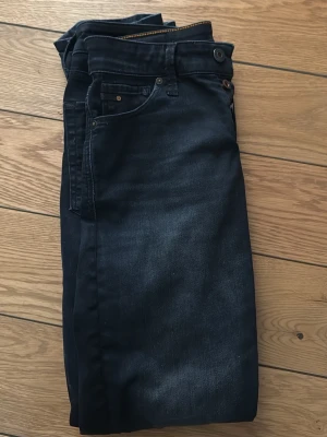 Svarta jeans från Jack & Jones - Snygga svarta jeans från Jack & Jones. Jeansen är slim fit i storleken 31/32 och har inga synliga defekter. Jeansen är knappt använda och i mycket bra skick. Skriv gärna om du har frågor!