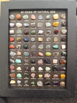 Tavla med 80 olika ädelstenar - Snygg tavla med 80 olika naturliga ädelstenar och mineraler, perfekt som dekoration eller för dig som älskar kristaller. Stenarna är polerade och varierar i färg och form, inramade i en svart träram. Namn på varje sten står tydligt under varje sten.