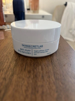 SKINSECRETLAB Anti-Puff Eye Patches - Fräscha ögonpatches från SKINSECRETLAB som hjälper mot svullnad, torrhet och trötta ögon. Kommer i en rund, vit plastburk med blå text. Perfekt för dig som vill pigga upp huden under ögonen.