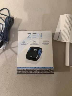 Cronus Zen adapter för spelkonsoler - Cronus Zen är en kompakt svart och blå adapter för spelkontroller till PS4, Xbox One, Nintendo Switch, Xbox Series X|S och Xbox 360. Med USB-anslutning och stöd för avancerade funktioner som aim assist och rapid fire. Perfekt för gaming och anpassning av kontroller. Jag har tillochmed köpt och laddat upp en färdig script till zen:nen