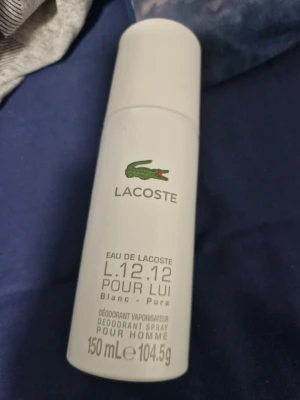 Not used Lacoste L.12.12 Pour Lui Blanc 150ml - Lacoste L.12.12 Pour Lui Blanc är en deodorant spray för män i en stilren vit flaska med den klassiska gröna krokodilloggan. Flaskan rymmer 150 ml och har en modern, cylindrisk form. Perfekt för dig som gillar fräscha och rena dofter.