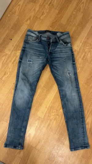 Blå slitna  jeans - Ettt par super fetta Jack and Jones jeans i storlek 29:30😄 har använts sparsamt och har inga defeekter samt missfärgningar. Hör av vid minsta frågan och priset kan diskuteras vid en snabb affär.