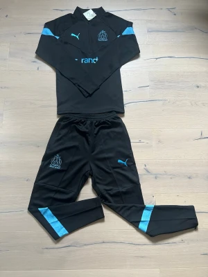Marseille tracksuit  - Helt ny Marseille tracksuit, storlek M passar någon som är runt 180-185 cm lång, hör gärna av er vid fundering