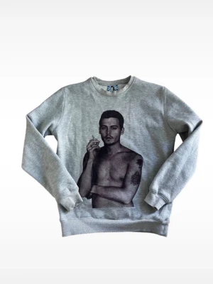 Grå sweatshirt med tryck - Grå sweatshirt med rund hals och ett stort tryck av en svartvit bild på johnny Depp på framsidan. Tröjan har långa ärmar och ribbade muddar vid ärmslut och nederkant. Perfekt för dig som gillar statement-plagg och streetwear.