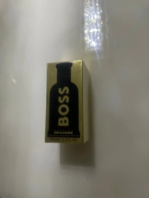 BOSS Bottled Eau de Toilette 100 ml - En helt ny oöppnad parfym som är Snygg och lyxig parfym från BOSS i en guldfärgad förpackning med svart siluett av parfymflaskan på framsidan. Flaskan innehåller 100 ml Eau de Toilette och har en modern, maskulin doftprofil. Perfekt för dig som vill ha en klassisk och stilren parfym.Den passar extra bra när vinter och våren kommer 