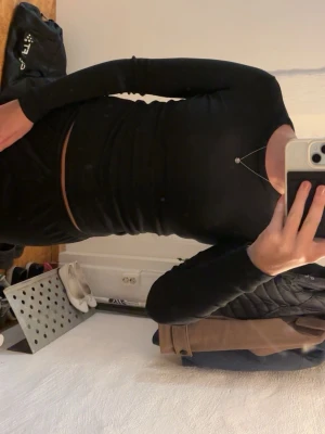 Svart långärmad topp från Ginatricot - En svart, ribbad långärmad topp från Ginatricot, basically basics-kollektionen. Toppen har en tight passform och är tillverkad i mjuk bomullsmix. Perfekt att styla med jeans eller kjol för en clean look. Ett jättelitet hål på armen som knappt syns (se sista bilden)