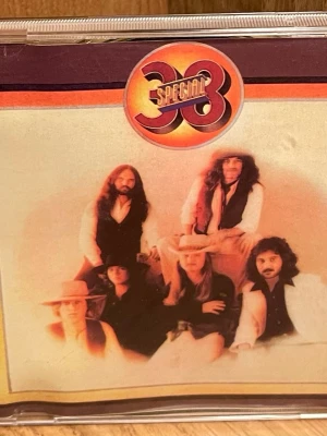 38 Special CD - CD med 38 Specials debutalbum. Omslaget har ett retroinspirerat foto på bandmedlemmarna och logotypen i rött och orange. Baksidan visar låtlista och ytterligare bandfoto. Perfekt för dig som gillar klassisk rock och samlar på ikoniska album. Perfekt Skick