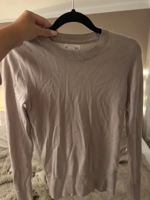 Beige tunn stickad tröja - Säljer en beige tunn stickad tröja från  Holly & Whyte. Tröjan har rund halsringning, långa ärmar och en enkel, stilren design. Perfekt att matcha med jeans eller kjol för en clean look.