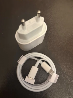 Vit laddare och kabel till mobil - Säljer en vit USB-väggadapter med två stift och tillhörande vit laddningskabel med Lightning-kontakt. Perfekt för dig som behöver extra laddare till mobilen. Passar de flesta moderna smartphones med Lightning-port.