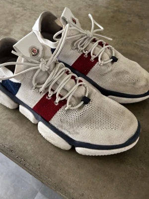 Moncler skor - Säljer ett par vita Moncler Bubble sneakers. Skorna har en Moncler-logga på plösen. 