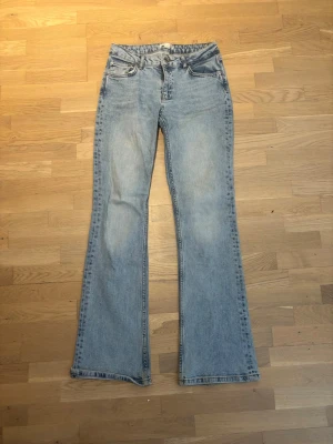 Ljusblå bootcut jeans - Säljer ett par ljusblå bootcut jeans med låg midja. De är i storlek 164 men skulle säga att de passar 32-34