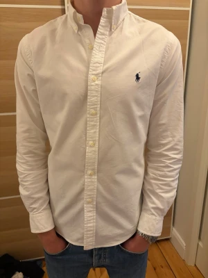 Polo Ralph Lauran skjorta - Säljer denna vita Ralph Lauran skjorta. Den är i storlek S och i mycket bra skick bortsett från sminkfläcken på bakre armen (se bild 5). Hör av er vid frågor och funderingar. 