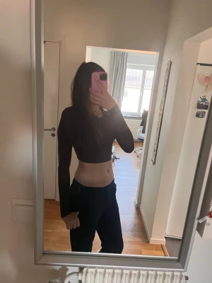 Mörkbrun croppad långärmad topp - Säljer en mörkbrun croppad topp med långa ärmar. Toppen har en tight passform och är perfekt för dig som gillar en enkel men snygg stil. Materialet känns mjukt och stretchigt, vilket gör den bekväm att bära hela dagen.