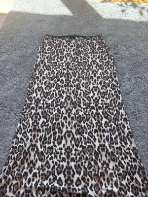 Leopardmönstrad långkjol med rosett - Säljer en långkjol från Gina tricot med leopard mönster. I midjan så har den fin spets med en rosett