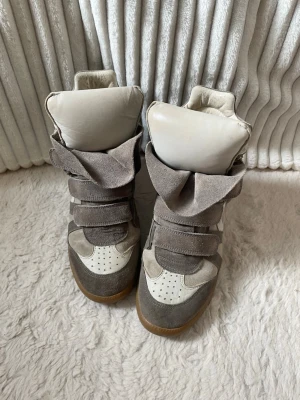 Beige Isabel Marant skor  - Äkta Isabel Marant Bekett sneakers i taupe/greige med detaljer i mocka och läder, med dold kilklack och kardborreband. Strl 39 