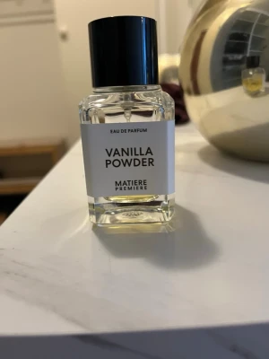 Vanilla Powder parfym från Matiere Premiere - Vanilla Powder Eau de Parfum från Matiere Premiere. Flaskan är genomskinlig med svart lock och vit etikett. Parfymen har en ljusgul vätska och en stilren, modern design. Perfekt för dig som gillar dofter med vaniljtoner.