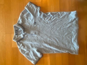 Ljusblå piké från Fred Perry - Säljer en ljusblå pikétröja från Fred Perry med klassisk krage och knappar framtill. Storlek s men sitter som 170. Använd max 5 gånger!