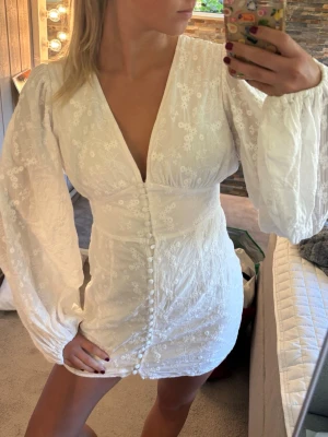 Vit Adoore klänning - Hej!💕 Säljer denna jättefina vita klänning i storlek 38. Den köptes för cirka 2 månader sedan och är endast använd ett fåtal gånger. Den är i väldigt fint skick, utan fläckar eller andra skador.  En knapp saknas framtill, men det är knappt märkbart (syns på bilden), därav ett längre pris. Nya knappar finns dock att hämta i Adoores butik om man vill komplettera. Nypris: 1495 kr
