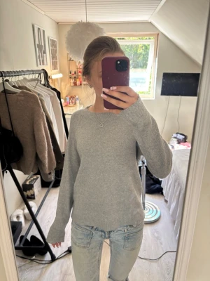 Ljusgrå stickad tröja Vero Moda - Ljusgrå stickad tröja från Vero Moda i storlek XS. Tröjan har rund halsringning, långa ärmar och ribbade muddar vid ärmslut och nederkant. Enkel och stilren design som passar till det mesta. Perfekt för lager på lager under kyligare dagar.