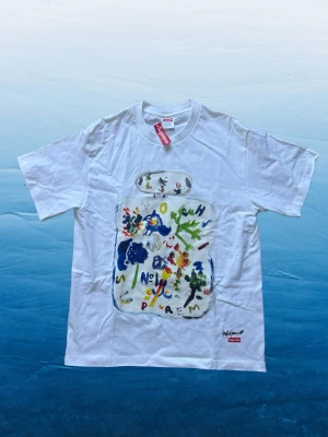 Vit Supreme t-shirt - Riktigt snygg vit T-shirt från Supreme i storlek M, med snyggt tryck framtill. Skön passform och sitter riktigt bra på. En riktigt fet piece som ger starka archive/vintage-vibbar.