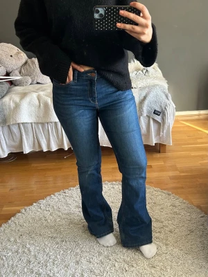 Blå bootcut jeans med hög midja - Säljer ett par snygga blå bootcut jeans med hög midja och klassisk femficksdesign. Jeansen är ifrån Lindex och är i storlek 40!💞💞💞
