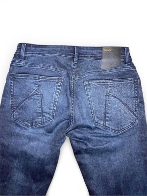 Mörkblå slim jeans från Chasin' - Snygga mörkblå slim fit jeans från Chasin' med klassisk femficksdesign och coola detaljer på bakfickorna. Jeansen har knappgylf och är tillverkade i stretchig denim för extra komfort. Perfekta för dig som gillar en smalare passform.