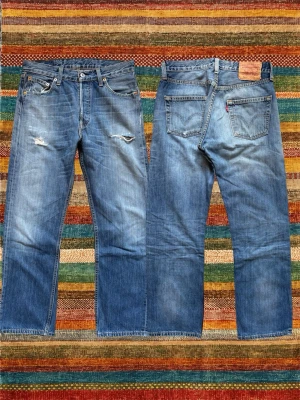*Straight fit* Levi’s 501 med Slitningar - Ett par extremt snygga Levi’s jeans med en trevlig wash! Modellen kallas 501 och är rak! Oerhört fina slitnigar på dessa. Storlek 29/30, hör av dig vid frågor! (Mått på sista bilden)