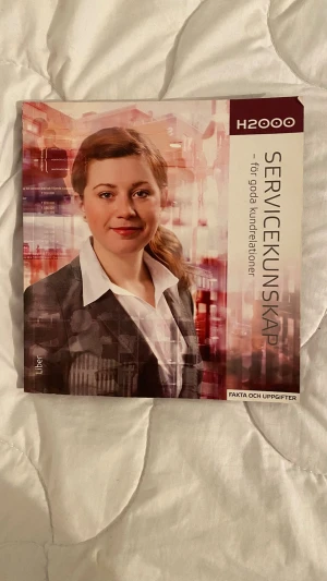 H2000 Servicekunskap kursbok - Kurslitteratur H2000 Servicekunskap – för goda kundrelationer. Boken har ett modernt omslag i vinrött och vitt med en porträttbild på framsidan. Innehåller fakta och uppgifter om service, kundbemötande och kommunikation. Perfekt för gymnasiet eller vuxenutbildning.