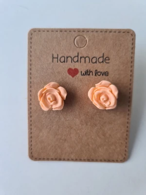 Handgjorda rosformade örhängen - Supersöta handgjorda örhängen i form av persikofärgade rosor. De är små och detaljerade, perfekta för dig som gillar blommiga accessoarer. Gjorda för hand av mig i polymerlera. 