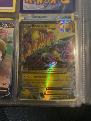 Pokémonkort Sandaconda V & Manectric EX - Två Pokémonkort: Sandaconda V med 220 HP och Land Crush-attack, samt Mega Manectric EX med 210 HP och Turbo Bolt-attack. Båda korten har färgstarka illustrationer och holografiska detaljer. Perfekt för samlare eller Pokémon TCG-spelare.