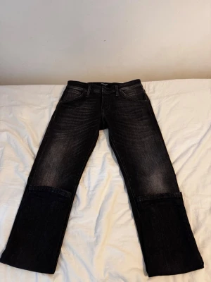 Svarta slim fit jeans - Säljer ett par svarta jeans med raka ben. Materialet är denim med en något tvättad look som ger en cool vibe. Perfekta för dig som gillar en avslappnad men ändå stilren stil. Använda endast 1 gång, nypris ca 1050kr. Pris går att diskutera.