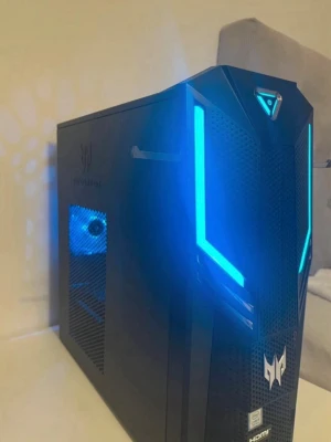 Acer Predator stationär gamingdator - Säljer en svart stationär gamingdator från Acer Predator-serien med futuristisk design och blå LED-belysning. Chassit har meshpaneler, tydlig Predator-logga och sidofönster som visar inbyggda fläktar. Perfekt för dig som vill ha en snygg och kraftfull dator till gaming.