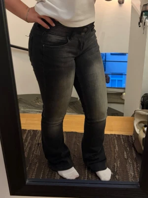 Svarta/gråa bootcut jeans - Snygga svarta jeans med tvättade detaljer. Lågmidjade. Perfekta för en trendig och avslappnad look.
