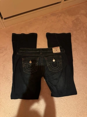 Mörkblå bootcut jeans True Religion - Säljer mina trueys för de är lite för stora för mig, de är i storlek 29 och stretchigt material. Dom är använda minst 5 gånger så dom är så helt nya. Hör av er om ni har några frågor!! 💞