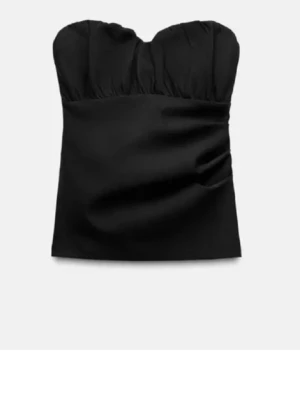 Svart bandeau tubtopp - Stilren svart bandeau tubtopp med lätt rynkad överdel och axelbandslös design. Liten i storlek så den sitter typ som en M, !!!!!sömmen vid kedjan har spräckt så de är ett litet band som sticker ut precisbubfer armen så de är inget märkvärdigt 