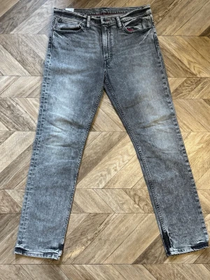 Levi's 511 Selvedge(?) - Snygga grå tvättade jeans från Levi's med klassisk femficksmodell och raka ben. Jeansen har en diskret slitning och den ikoniska röda Levi's-lappen på bakfickan. Perfekta för en avslappnad och trendig look. Längd 109cm Bredd 45cm