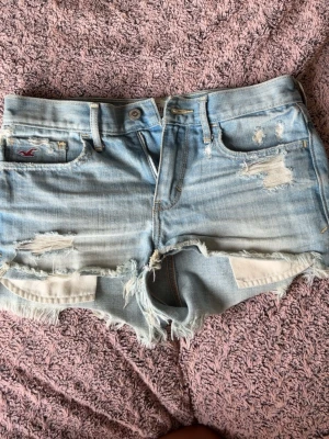 Ljusblå slitna jeansshorts Hollister - Säljer ett par ljusblå jeansshorts från Hollister med slitna detaljer