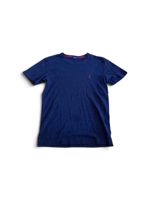 Marinblå t-shirt från Ralph Lauren - Klassisk marinblå t-shirt från Ralph Lauren med röd broderad logga på bröstet. Tillverkad i mjuk bomull och har en normal passform med korta ärmar och rund hals. Perfekt basplagg för en clean och stilren look.