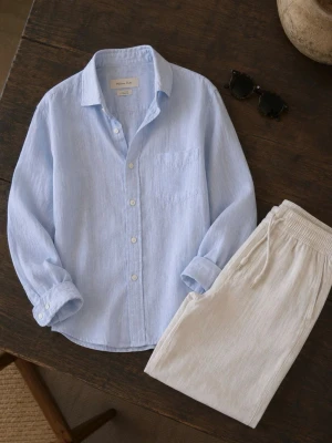 Ljusblå linneskjorta Massimo Dutti - Säljer en stilren ljusblå skjorta i 100% linne från Massimo Dutti. Skjortan har klassisk krage, bröstficka och vita knappar framtill. Perfekt för en avslappnad men snygg look. Ärmarna är långa och kan enkelt vikas upp för en mer casual stil.