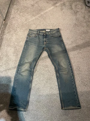 Tiger of Sweden jeans - Säljer ett par blå jeans med raka ben och snygga slitningar på framsidan. Jeansen har klassisk femficksmodell, ljus tvätt och kontrastsömmar. Perfekta till en avslappnad stil och passar till det mesta i garderoben. Storlek 29/30