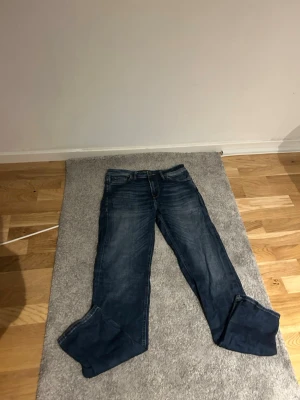 Mörkblå jeans från Jack & Jones - Säljer ett par mörkblå jeans från Jack & Jones med klassisk femficksmodell och snygga slitningar. Jeansen har normal midja, raka ben och är tillverkade i denim med lätt tvättad look. Perfekta för en avslappnad och trendig stil. W30 L34