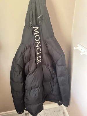 Svart Moncler dunjacka - Säljer en svart dunjacka från Moncler med en dragkedja som fattas.